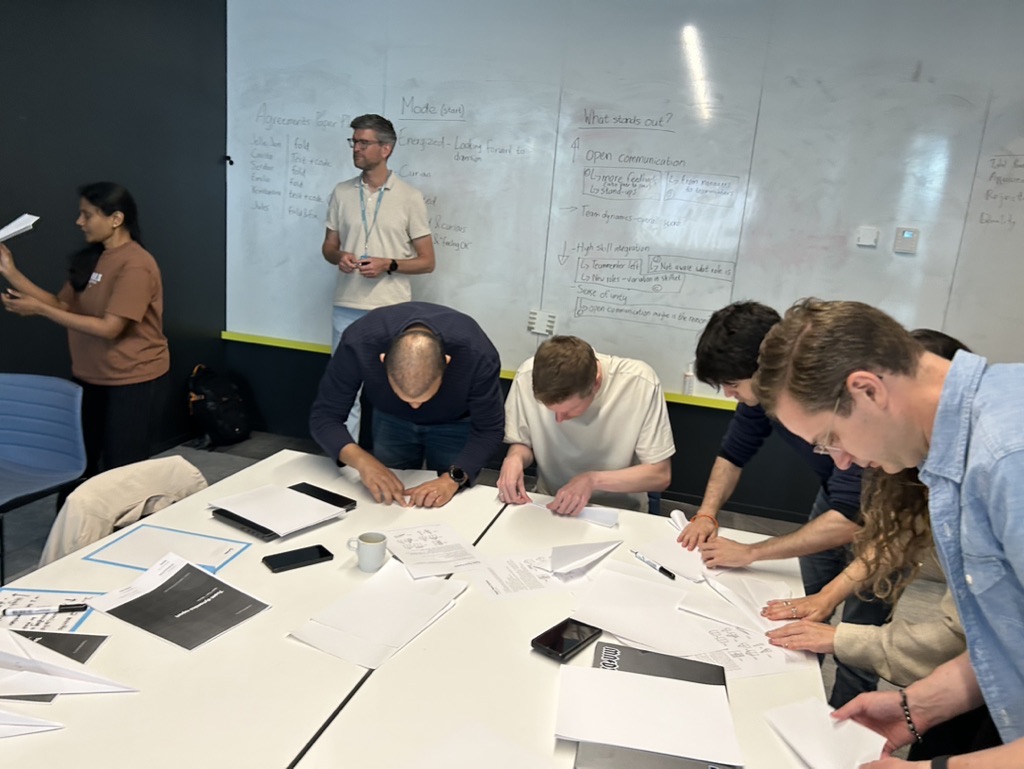 Team werkt tijdens een workshop rond een tafel aan het verbeterproces