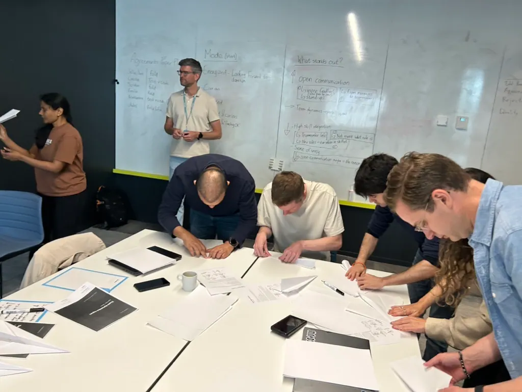 Team werkt tijdens een workshop rond een tafel aan het verbeterproces